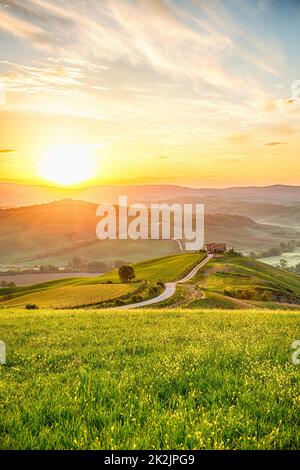 Alba sulle colline di un paesaggio rurale con una fattoria Foto Stock