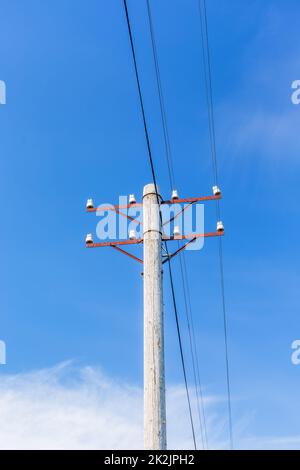 Vecchia linea telefonica Rusty contro un cielo estivo blu chiaro Foto Stock