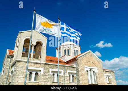 Sventolando la bandiera di Cipro e della Grecia con la chiesa ortodossa sullo sfondo. Foto Stock