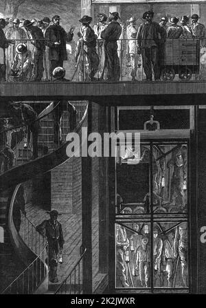 I minatori del giacimento di carbone le Creusot nel sud-est della Francia si riuniscono per il loro turno. Nella parte superiore viene controllato il lotto successivo per entrare nella gabbia. Sotto la gabbia piena di minatori che trasportano le loro lampade viene abbassata al livello di lavoro. Da 'le Journal de la Jeunesse' (Parigi, 1885). Incisione. Foto Stock