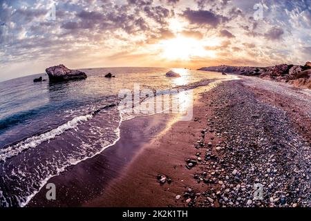 Tramonto sul mare vicino a Petra tou Romiou. Distretto di Paphos, Cipro Foto Stock