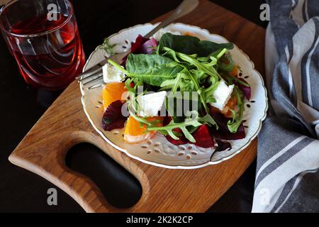Insalata con barbabietola, rucola, formaggio feta, arancia, spinaci su sfondo grigio vista dall'alto. Cibo sano. Insalata di primavera Foto Stock