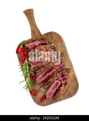 pezzo di ribeye di manzo arrosto tagliato a pezzi su un tagliere marrone d'annata, rara donanza. Deliziosa bistecca Foto Stock