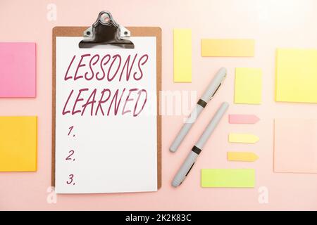 Lezioni di segno di scrittura della mano imparate. Concetto significato promuovere la condivisione e l'uso delle conoscenze derivate da esperienza molteplici assortiti Collezione Office Stationery Foto posto sul tavolo Foto Stock