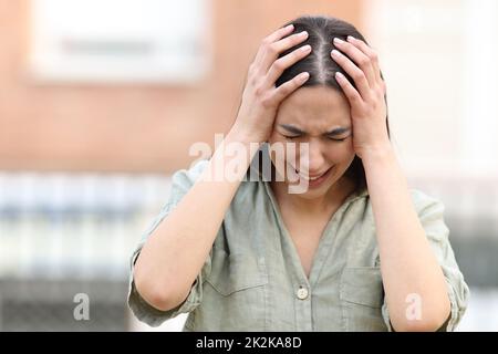 Donna triste lamentarsi disperatamente per strada Foto Stock