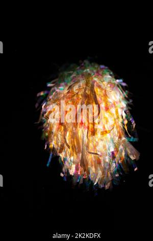 Una visione astratta della luce attraverso un groviglio di materiale iridescente che forma una galassia simile a un'esplosione di luce. Ideale per pareti, screensaver o sfondo. Foto Stock