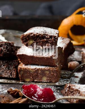 pezzi quadrati di brownie al cioccolato al forno cosparsi di zucchero a velo sul tavolo Foto Stock