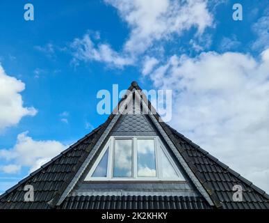 Finestra a tetto aperto in stile velluto con tegole nere. Foto Stock