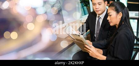 Due uomini d'affari che si riuniscono discutendo i grafici e i grafici che mostrano i risultati Foto Stock