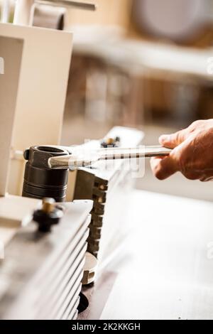 mano di un lavoratore del legno che imposta una fresa Foto Stock