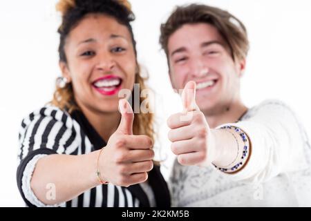 Due giovani felici che danno i pollici in su Foto Stock