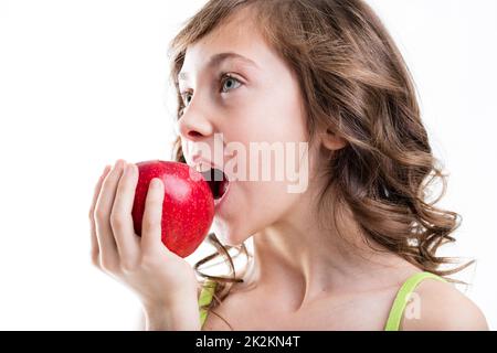 la ragazza mangia mela rossa su sfondo bianco Foto Stock