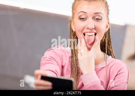 Divertente giovane donna che tira una faccia goofy Foto Stock