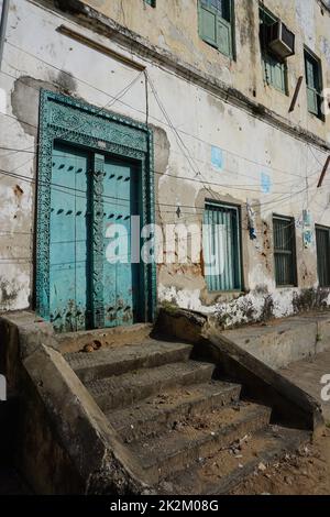 Porta in legno turchese riccamente ornata in Stone Town, Zanzibar Foto Stock