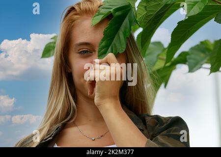 nasconde gli occhi meravigliosi dietro una foglia Foto Stock