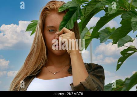 nasconde gli occhi meravigliosi dietro una foglia Foto Stock