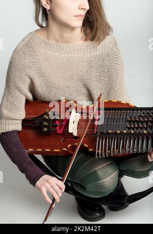 Giovane donna che gioca un tradizionale nyckelharpa Foto Stock