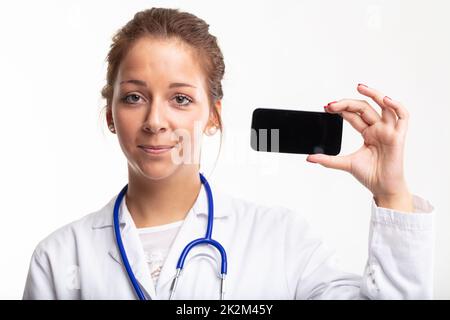 Giovane medico o infermiera che tiene in mano un telefono cellulare vuoto Foto Stock