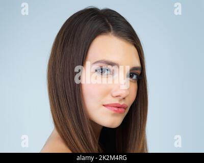 Affrontare il mondo naturalmente come lei è. Studio ritratto di una bella giovane donna in posa su uno sfondo blu. Foto Stock