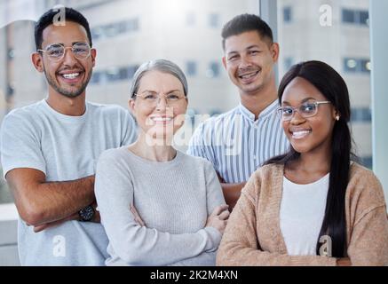 Ho il team migliore nel settore. Girato di un team diversificato di colleghi insieme nel loro ufficio al lavoro. Foto Stock