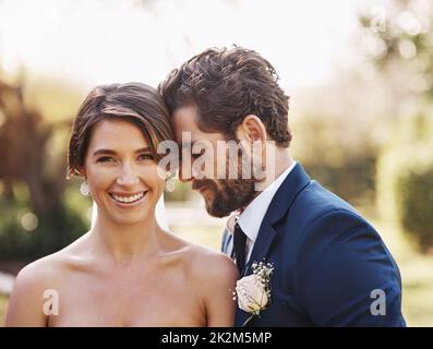 So che il nostro matrimonio sarà felice. Foto ritagliata di una giovane sposa affettuosa sorridente mentre si trova all'aperto con il suo sposo il giorno del matrimonio. Foto Stock