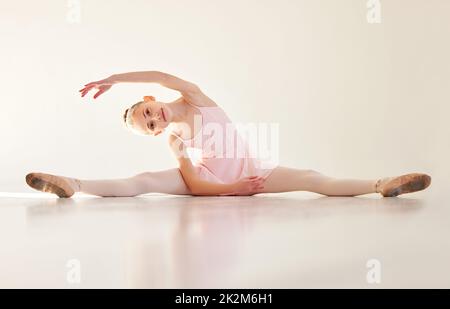 La perfezione tecnica è insufficiente, bisogna fare pratica. Scatto di una giovane ballerina che si allunga in uno studio di danza. Foto Stock