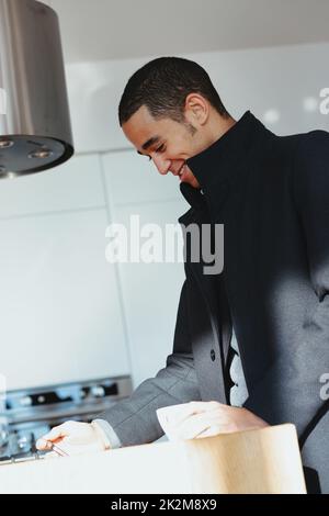 Giovane uomo nero alla moda che si gode una tazza di caffè in cucina Foto Stock