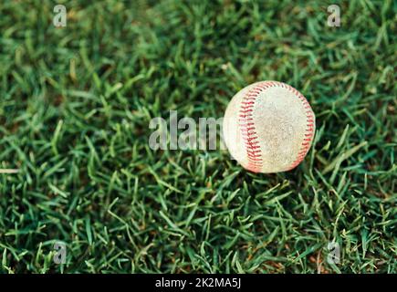 Lascia giocare un po' di baseball. Shot di un baseball sdraiato su un campo. Foto Stock