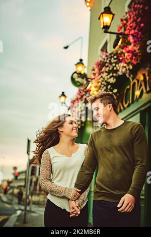 Fuori per una passeggiata in città. Scatto corto di una coppia giovane amorevole fuori su una data. Foto Stock