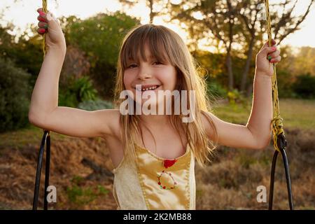 I tempi di divertimento sono in pieno swing. Ritratto di una bambina seduta su un swing esterno. Foto Stock