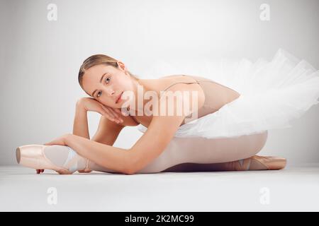 Il mio obiettivo è quello di stupire il pubblico. Ritratto a tutta lunghezza di una giovane ballerina femminile attraente in studio su sfondo grigio. Foto Stock