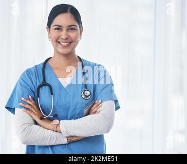 Un sorriso è il primo passo per far sentire meglio i pazienti. Shot di un medico in piedi con le braccia incrociate. Foto Stock