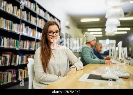 Studiare è la mia priorità numero uno. Ritratto corto di una giovane studentessa universitaria studentessa studentessa in biblioteca. Foto Stock