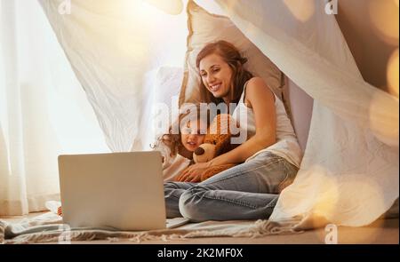 Questa è la mia parte preferita. Scatto di una madre e di una figlia che si lega e guarda un film su un computer portatile in camera da letto. Foto Stock