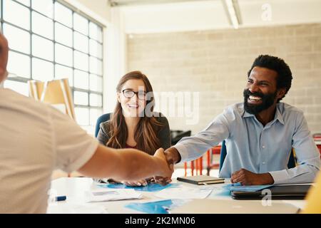 Lasciate che il legame con la creatività e il business cominci. Scatto di dipendenti creativi che scuotono le mani in un ufficio moderno. Foto Stock