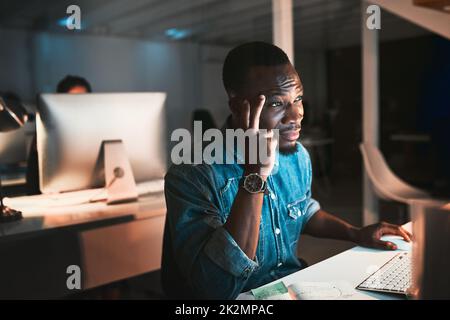 HES ha colpito un muro. Scatto ad alta angolazione di un giovane designer maschile che ha un aspetto stressato mentre lavora sul suo computer in ufficio. Foto Stock