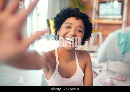 Ciao ragazzi. Ritratto girato di una giovane donna che agita mentre si registra a casa. Foto Stock