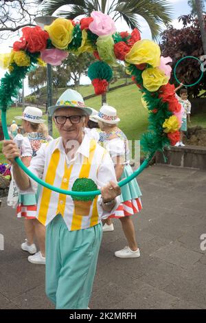 Uomo in costume da fantasia che tiene anello di fiori a Funchal Madeira Foto Stock