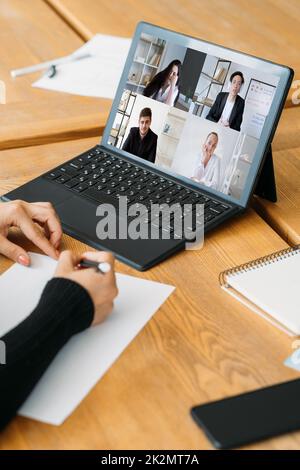Intervista video. Riunione remota. Teleconferenza internazionale. Donna d'affari stanca colleghi diversi guardando noiosa presentazione sullo schermo del notebook i Foto Stock