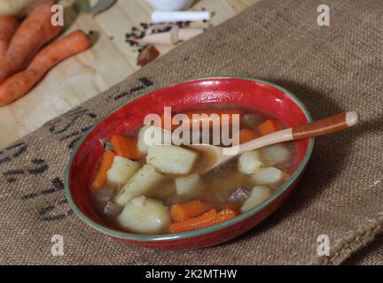 Stufato di manzo abbondante con patate e carote sulla busta di patate vintage burlap Foto Stock