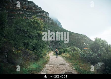 Vagare spesso, meraviglia sempre. Foto di un giovane uomo che percorre le montagne. Foto Stock