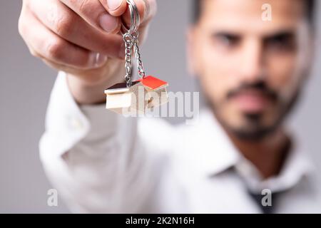 Uomo con portachiavi a forma di casa Foto Stock