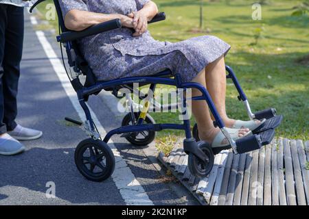 Assistenza e cura degli operatori asiatici anziani anziani o anziani anziana donna paziente seduta e felice su sedia a rotelle nel parco, sano forte concetto medico. Foto Stock
