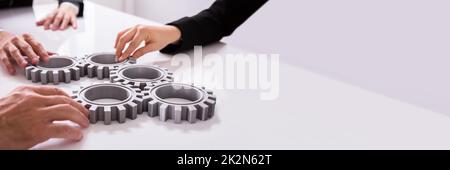 Imprenditori ingranaggi di giunzione sulla scrivania Foto Stock