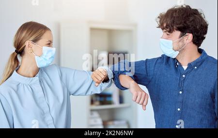 Il team aziendale, il gomito a gomito e la covida conformità con i dipendenti saluto con la distanza sociale in un ufficio. Uomo e donna in ufficio durante Foto Stock