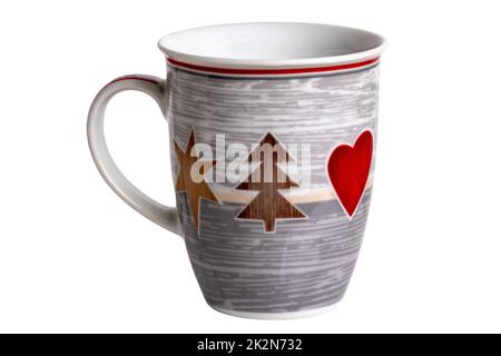 Primo piano di una tazza di ceramica bianca e grigia con motivi natalizi stampati, come un abete, una stella e un cuore isolati su sfondo bianco. Tracciato di ritaglio. Macro. Foto Stock