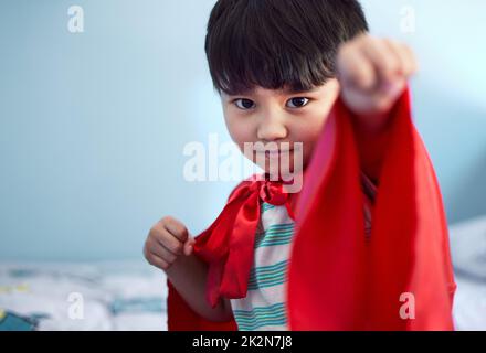 Oggi sarò il mio supereroe. Ritratto di un adorabile ragazzino che finge di essere un supereroe mentre gioca a casa. Foto Stock