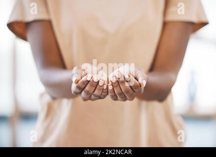 Donna nera con le mani fuori per carità, donazione o aiuto con gentilezza o rispetto. Le palme si aprono a chiedere, dare o ricevere speranza o sostegno nella povertà Foto Stock