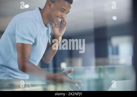 Fare un successo della giornata facendo tutte le vendite. Scatto di un giovane uomo d'affari che lavora in un call center. Foto Stock