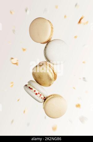 Biscotti al macaron bianchi, gialli e dorati. Piccoli amaretti francesi colorati e dolci Foto Stock